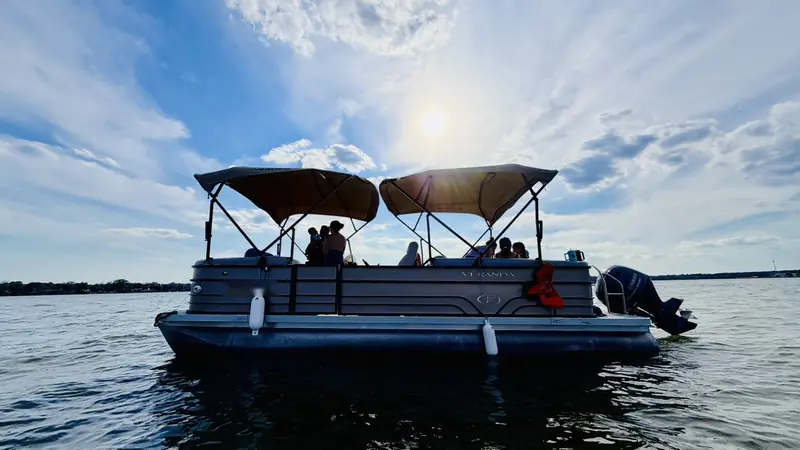 Veranda V22RC pontoon on Lake Conroe with passengers aboard and the sun behind the shaded tops