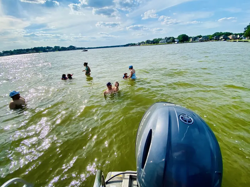 Swimmers cooling off in Lake Conroe behind the outboard motor of the Veranda V22RC