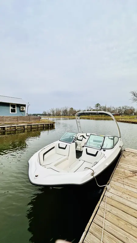 Yamaha AR190 tied to a wooden dock on Lake Conroe on an overcast day, bow view with the wake tower